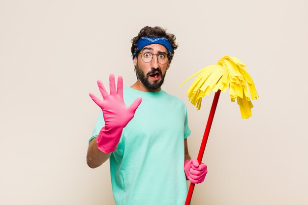 Jeune homme se sentant stupéfait et effrayé, craignant quelque chose d'effrayant, avec les mains ouvertes à l'avant