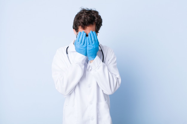 Jeune homme se sentant triste, frustré, nerveux et déprimé, couvrant le visage des deux mains, pleurant. concept de coronavirus