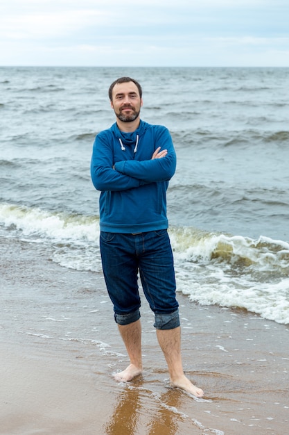 Un jeune homme se tient au bord de la mer