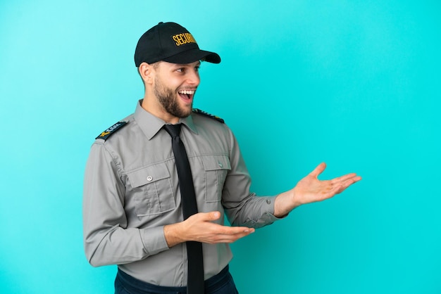 Jeune homme de sécurité isolé sur fond bleu avec une expression faciale surprise