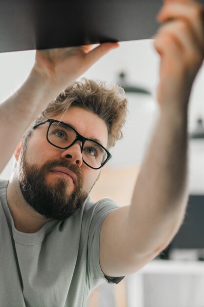 Jeune homme séduisant assemble un artisan de meubles et un concept d'objets d'intérieur