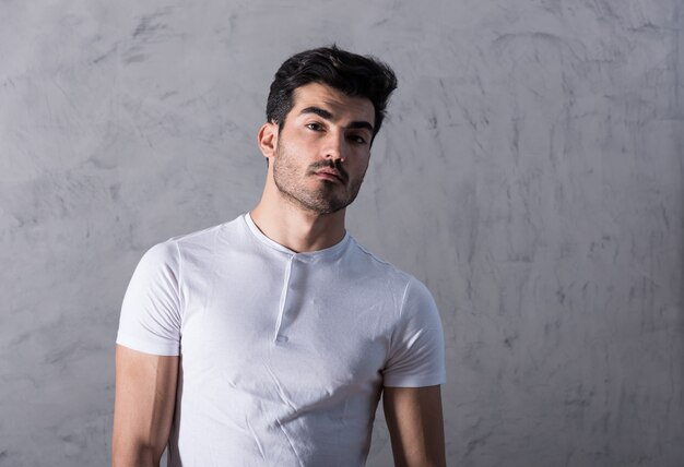 Un jeune homme sérieux dans un t-shirt blanc