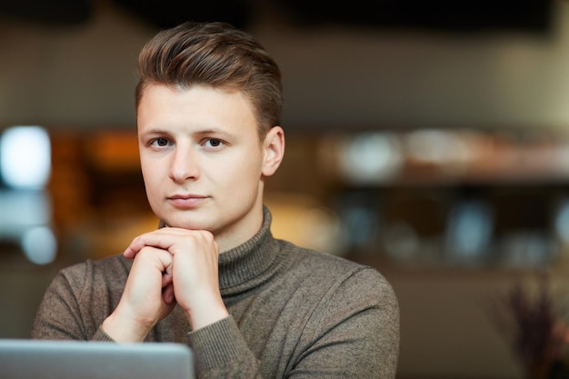 Jeune homme sérieux en pull marron