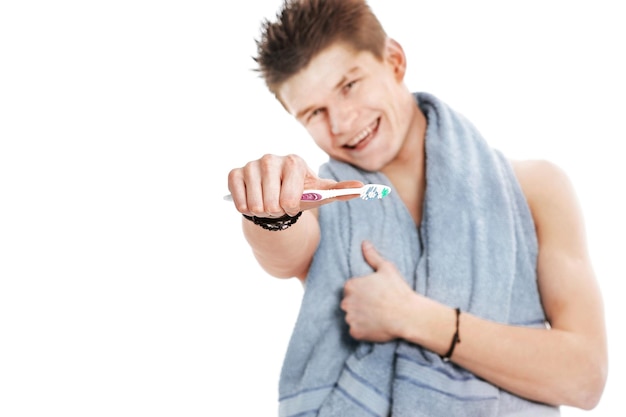 Jeune homme avec serviette et brosse à dents isolé sur blanc
