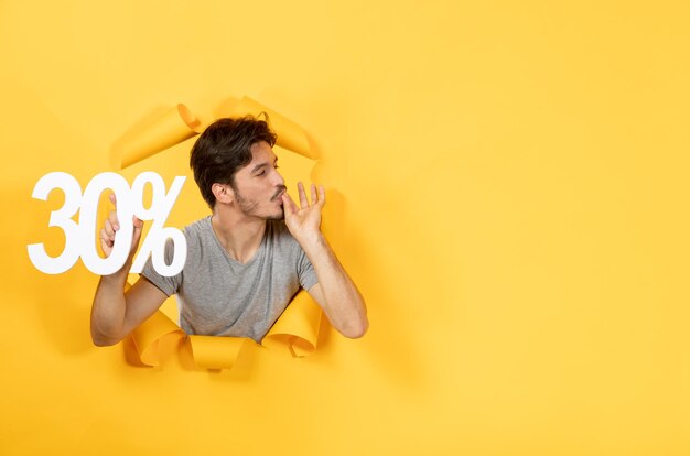 Jeune homme avec signe d'inscription sur une surface jaune déchirée