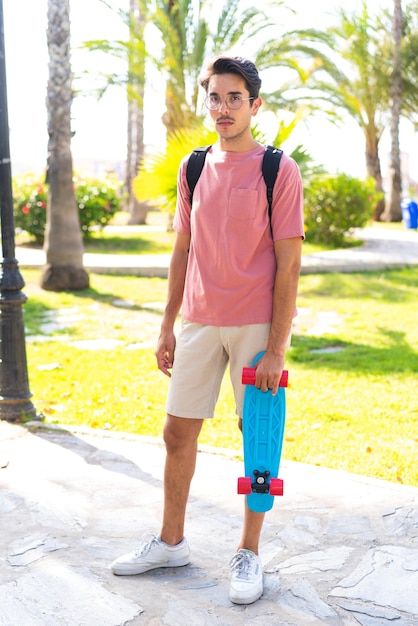 Jeune homme avec skate à l'extérieur