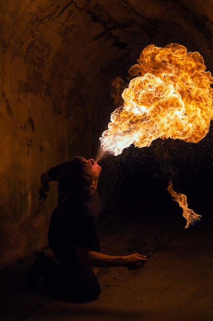 Jeune homme soufflant le feu de sa bouche