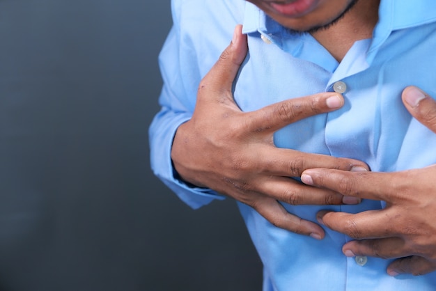 Jeune homme souffrant de coeur et tenant sa poitrine.