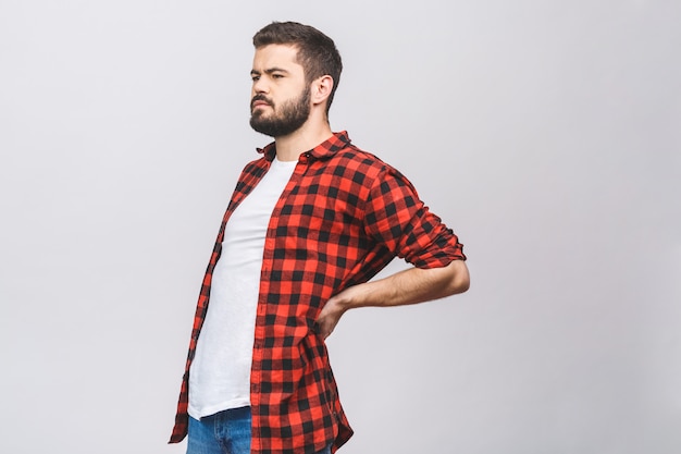 Jeune homme souffrant de maux de dos isolé sur fond blanc. Concept de maux de dos.