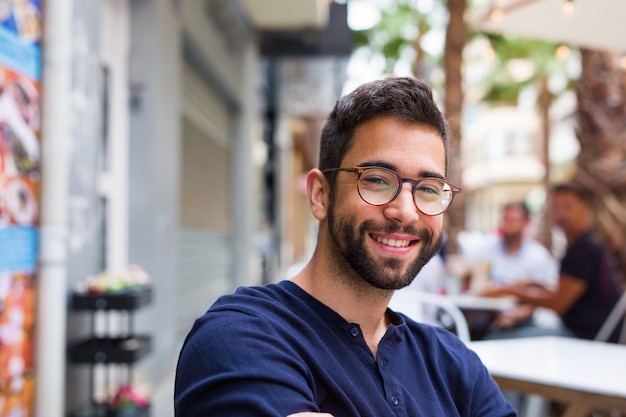 Jeune homme souriant au bar