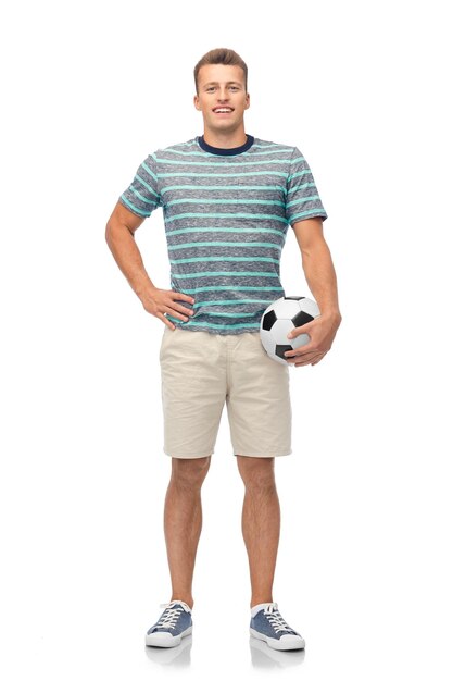 Un jeune homme souriant avec un ballon de football.