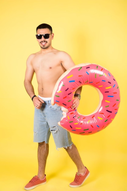 Un jeune homme souriant et heureux tient un anneau gonflable