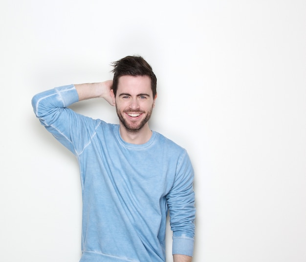 Jeune homme souriant avec la main dans les cheveux