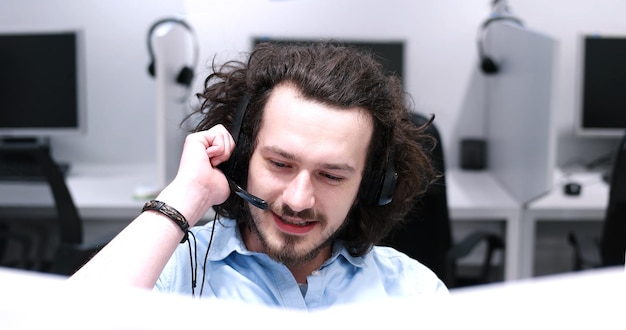 jeune homme souriant opérateur de centre d'appels faisant son travail avec un casque