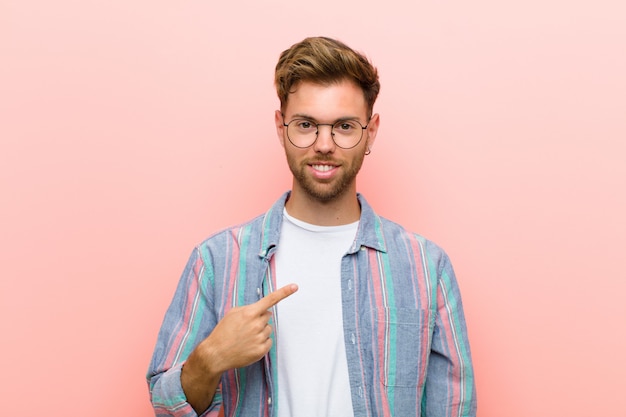 jeune homme souriant et pointant vers soi