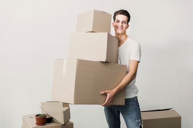 Jeune homme souriant tenant des boîtes en carton