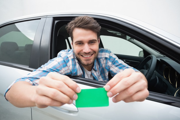 Jeune homme souriant et tenant la carte