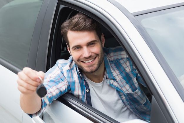 Jeune homme souriant et tenant la clé