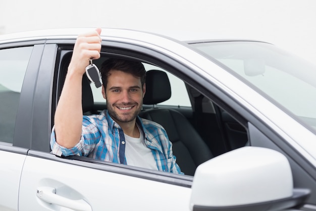 Jeune homme souriant et tenant la clé