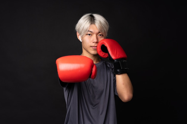 Jeune homme de sport asiatique sur noir isolé