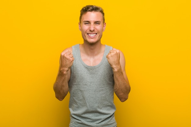 Jeune homme de sport caucasien applaudissant sans soucis et excité. Concept de victoire.