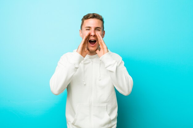 Jeune homme de sport caucasien criant excité à l'avant.