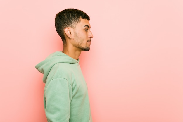 Jeune homme de sport hispanique regardant à gauche, pose de côté.