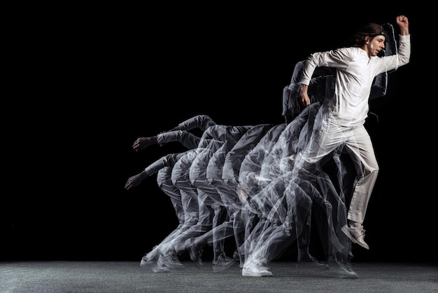 Jeune homme sportif danse hiphop isolé sur fond noir avec effet stroboscopique Motion