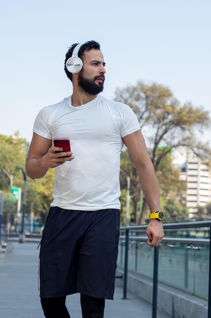 Jeune homme sportif envoyant des SMS au téléphone après l'entraînement