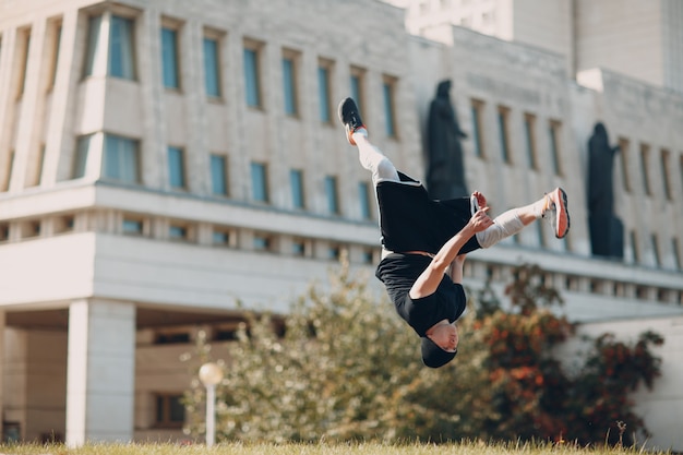 Jeune homme sportif faisant du parkour dans la rue de la ville.