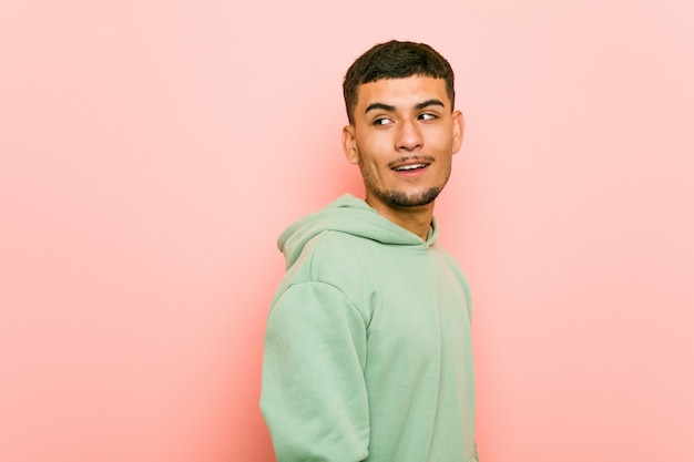 Jeune homme sportif hispanique a l'air souriant, joyeux et agréable.