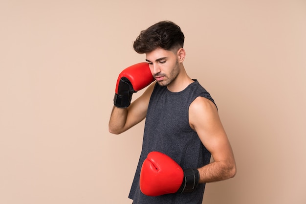 Jeune homme sportif isolé avec des gants de boxe