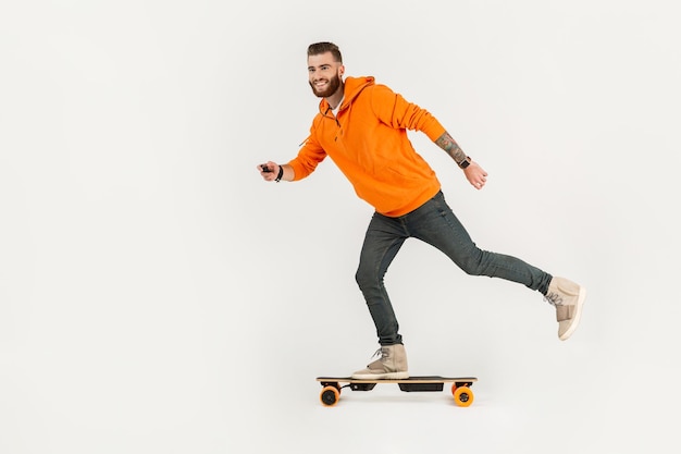 Jeune homme de style hipster faisant du skateboard sur un skateboard électrique