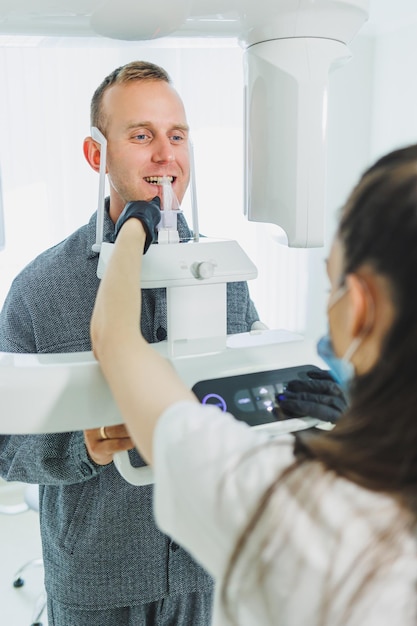 Photo un jeune homme a subi une tomodensitométrie de la mâchoire une image circulaire de la mâchoire en dentisterie moderne radiologie scanner panoramique