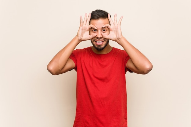 Jeune homme sud-asiatique gardant les yeux ouverts pour trouver une opportunité de succès.