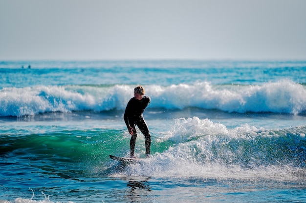 jeune homme surfant sur les vagues