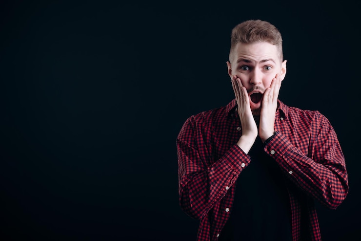 Photo un jeune homme surpris touchant ses joues