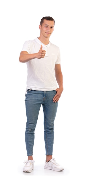 Jeune homme avec un T-shirt blanc heureux, avec son pouce isolé