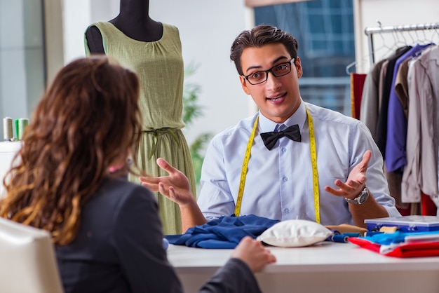 Jeune homme tailleur travaillant avec une cliente