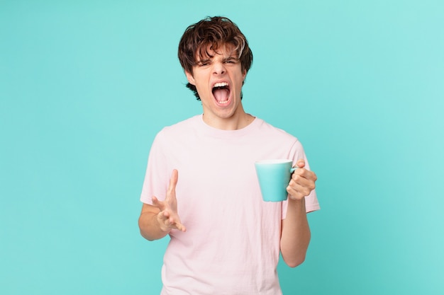 Jeune homme avec une tasse de café à la colère, agacé et frustré