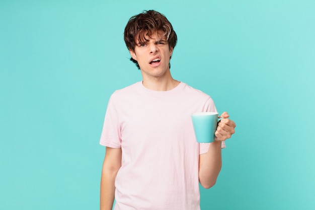 Jeune homme avec une tasse de café se sentant perplexe et confus