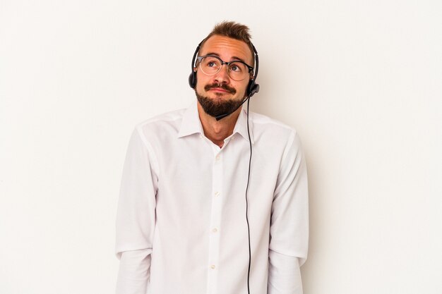 Jeune homme de télévendeur caucasien avec des tatouages isolés sur fond blanc rêvant d'atteindre des objectifs et des buts