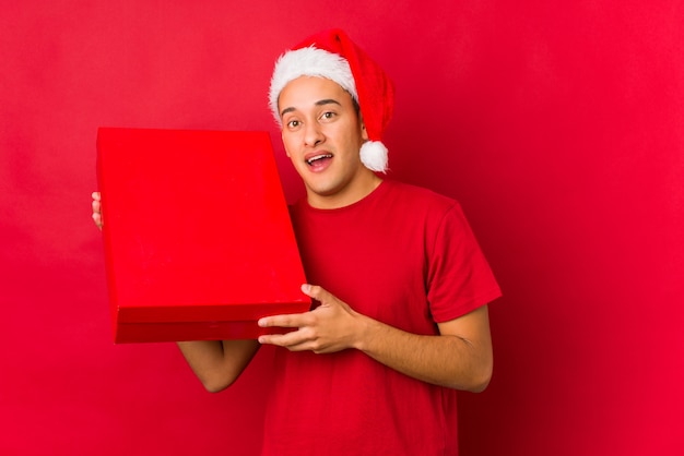 Jeune homme tenant un cadeau le jour de Noël