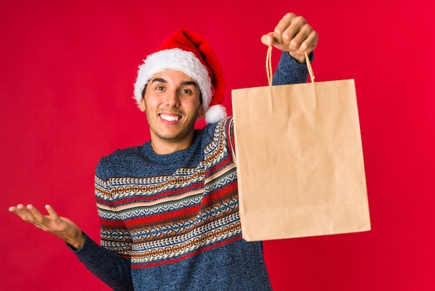 Jeune homme tenant un cadeau le jour de Noël