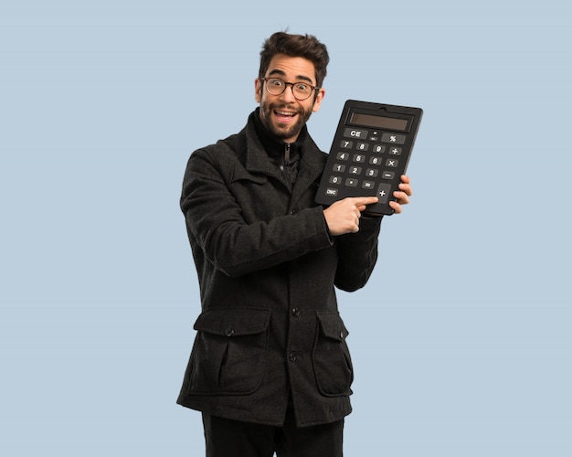 Jeune homme tenant une calculatrice