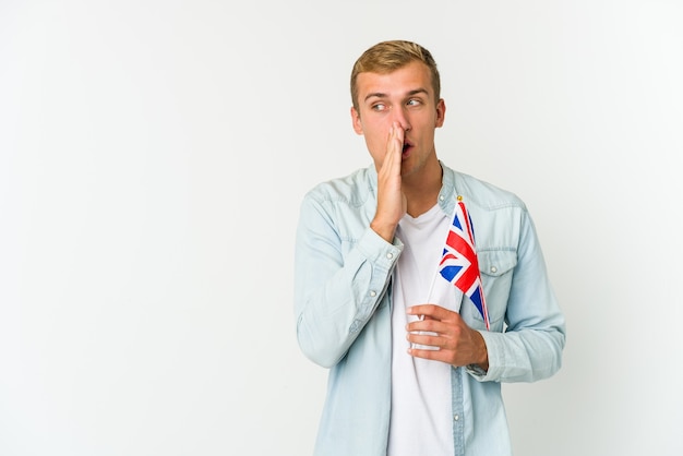 Jeune homme tenant un drapeau du Royaume-Uni touchant l'arrière de la tête, en pensant et en faisant un choix