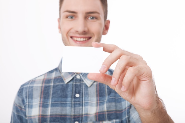 Jeune homme tenant une feuille de papier vierge blanche