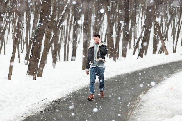 Un jeune homme tenant un fond d'hiver de téléphone