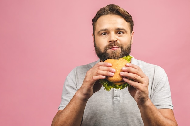 Jeune homme tenant un morceau de hamburger