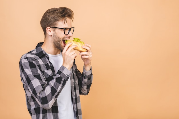 Jeune homme tenant un morceau de sandwich